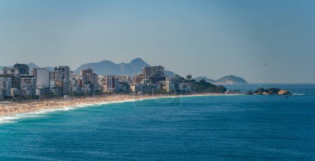 Photo for Ipanema Beach in Brazil bustles with crowds savoring a sunny summer day under blue skies. - Royalty Free Image
