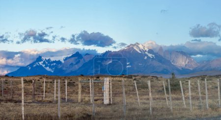 Rugged mountains with rustic fence at dusk.