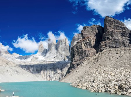 Téléchargez les photos : Voyageur solo admire le lac turquoise tranquille avant les montagnes majestueuses. - en image libre de droit