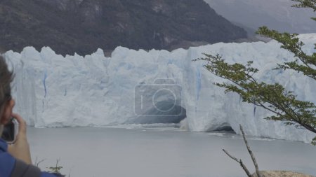 Tourist observes as icebergs calve from Perito Moreno Glacier.
