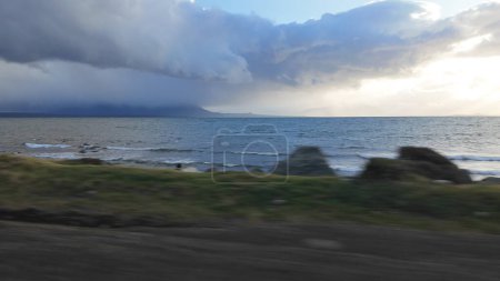 Sunset lake hyperlapse with storm clouds during a high-speed evening drive.
