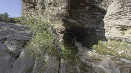 Foto de Vídeo en cámara lenta muestra un fuerte chorro de agua de una cueva oscura. - Imagen libre de derechos