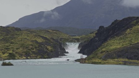 Des images au ralenti capturent une cascade majestueuse à Torres del Paine en cascade dans un lac vivant.