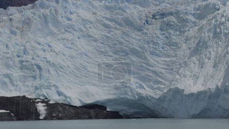 Aufgenommene Slow-Motion-Aufnahmen eines kalbenden Gletschers, bei dem Eisbrocken ins Meer stürzen und Spritzer erzeugen.