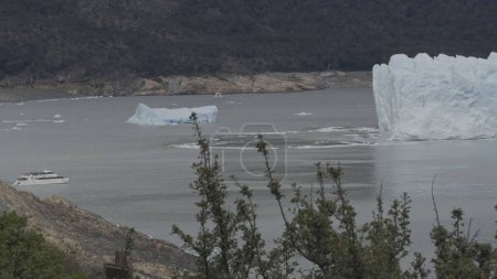 Touristen auf einem Boot in der Nähe eines Gletschers, um seine riesigen Eiswände zu beobachten.