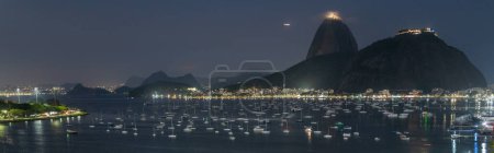 Impresionante panorama nocturno de la bahía de Ríos con barcos y montaña Sugarloaf.