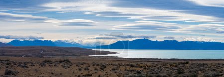 Impresionante paisaje nublado sobre un tranquilo lago y picos patagónicos.