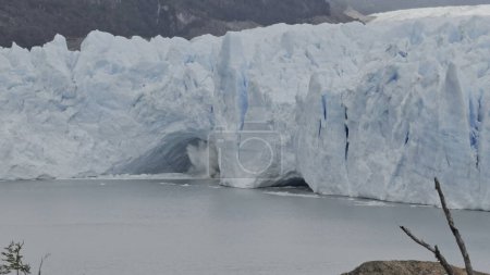 Ice chunks fall from Perito Moreno Glaciers cave into the water below.