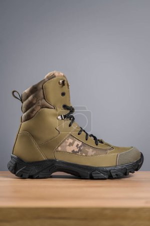 Photo for Khaki high military boots on a gray background - Royalty Free Image