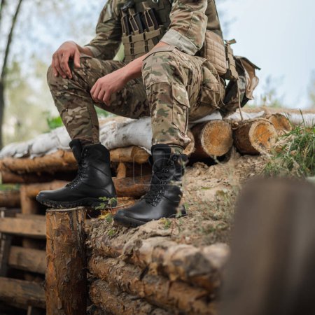 Téléchargez les photos : Un soldat militaire en uniforme spécial avec un sac à dos tactique près d'une tranchée - en image libre de droit
