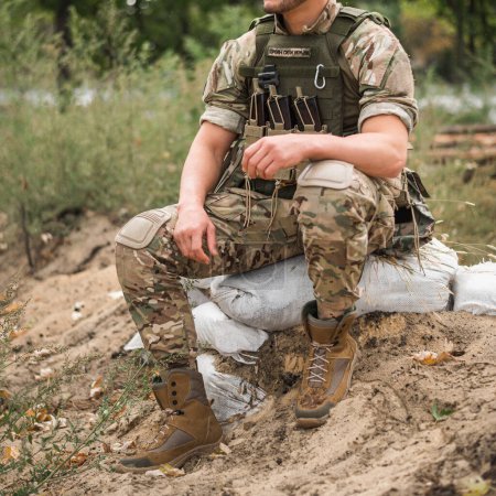 Téléchargez les photos : Un soldat militaire en uniforme spécial avec un sac à dos tactique sur le champ de bataille - en image libre de droit