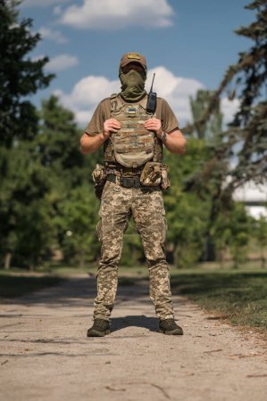 Photo for A military soldier in a special uniform with a tactical backpack in the forest - Royalty Free Image