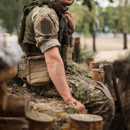 Téléchargez les photos : Un soldat militaire en uniforme spécial avec un sac à dos tactique près d'une tranchée - en image libre de droit
