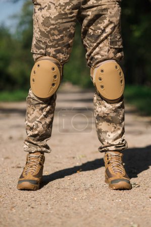 Soldat in Schutzuniform. Tarnschutzuniform. Ellenbogenschoner und Knieschoner für Soldaten