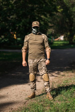 Photo for Soldier in protective uniform. Protective camouflage uniform. Elbow pads and knee pads for soldiers - Royalty Free Image