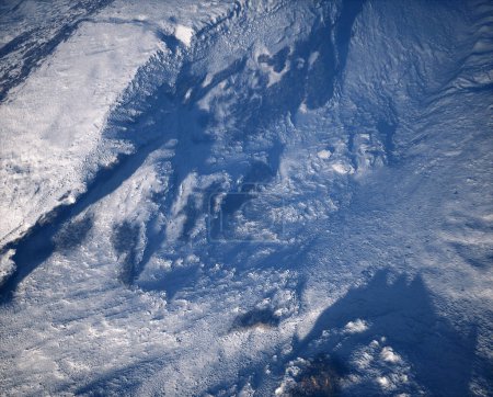 Foto de Aérea de terreno áspero con rocas y montañas cubiertas de nieve. - Imagen libre de derechos