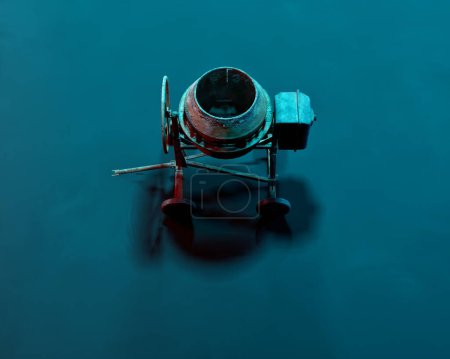 Foto de Mezclador de hormigón en luz de color verde azulado. Grabado en estudio. Vista de ángulo alto. - Imagen libre de derechos