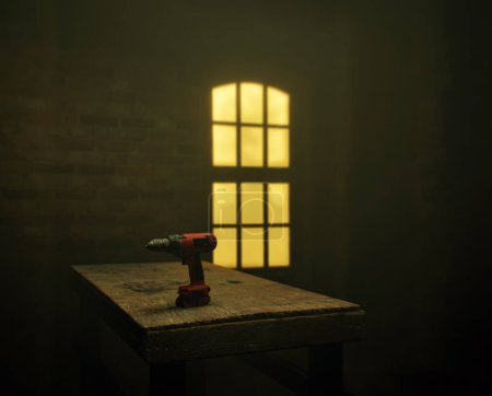 Foto de Taladro eléctrico rojo sobre una vieja mesa de madera junto a una ventana iluminada en un taller polvoriento. - Imagen libre de derechos