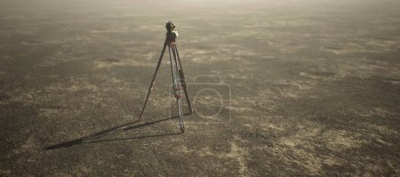 Téléchargez les photos : Arpenteur-géomètre sur trépied debout sur un grand paysage plat ouvert. - en image libre de droit