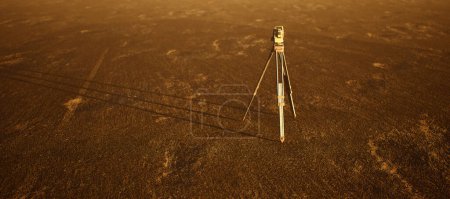 Téléchargez les photos : Arpenteur-géomètre sur trépied debout sur un grand paysage plat ouvert. - en image libre de droit