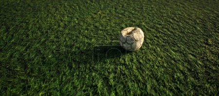 Photo for Worn old football on artificial grass. Lit by sunlight. - Royalty Free Image