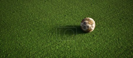 Téléchargez les photos : Porté vieux football sur gazon artificiel. Illuminé par la lumière du soleil. - en image libre de droit
