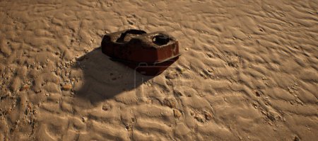 Foto de Jerrycan marrón oxidado que miente en arena ondulada de la playa. - Imagen libre de derechos