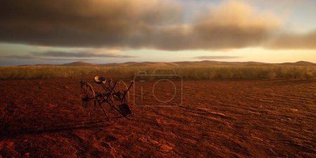 Téléchargez les photos : Ancien cultivateur dans le désert désolé au coucher du soleil avec ciel nuageux. - en image libre de droit