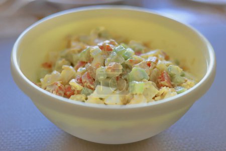 La salade de légumes avec sauce mayonnaise dans une assiette blanche sur la table