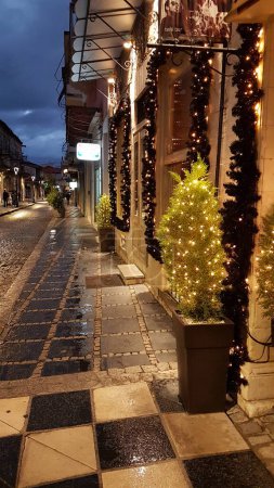 Téléchargez les photos : Noël saison rue café à ioannina ville grèce lumières tables chaises rue piétonne comme échiquier - en image libre de droit