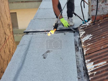 Foto de Asfalto terraza aislamiento impermeable instalación trabajo en el techo de un edificio de mantenimiento - Imagen libre de derechos
