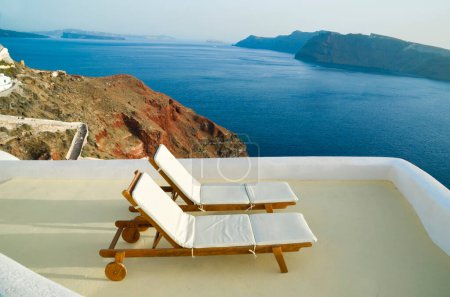 Téléchargez les photos : Santorini oia ville grreece vue sur la mer été destination touristique charis tables transat - en image libre de droit