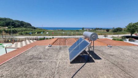 calentador solar en el techo por el mar bajo el sol de verano en el mediodía