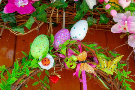 Téléchargez les photos : Easter Eggs wreath with flowers on front door. Traditional decoration for Easter. . High quality photo - en image libre de droit