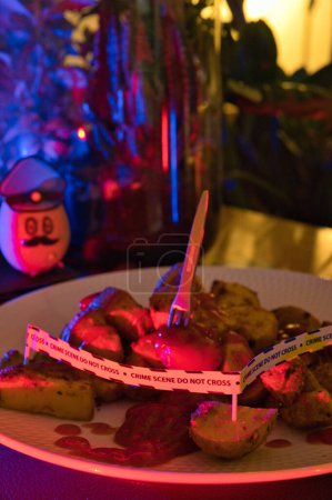 Photo for Potato dressed as a policeman in front of a plate with potato wedges shown as a crime scene. - Royalty Free Image