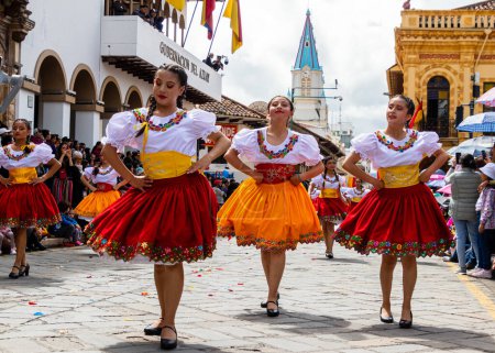 Foto de Cuenca, Ecuador - 11 de abril de 2023: celebración del Día de la Fundación. Desfile en el centro histórico de Cuenca. Grupo de jóvenes bailarinas folclóricas guapas en tela típica de la provincia de Azuay, ciudad de Cuenca - Imagen libre de derechos