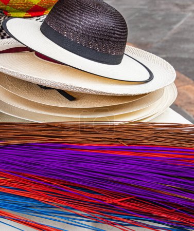 Téléchargez les photos : Chapeaux de paille Paja Toquilla faits à la main équatorienne (chapeau panama) et une paille colorée utilisée pour fabriquer des chapeaux. Souvenir populaire d'Amérique du Sud, Cuenca - en image libre de droit