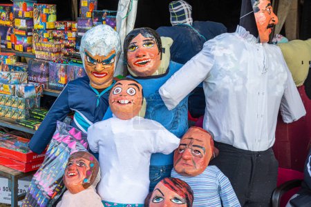 Foto de Cuenca, Ecuador-29 de diciembre de 2022: Muñecas de trapo o muñecos con máscaras divertidas, cómicas o políticas se venden en el mercado callejero de Monigotes. Serán quemados a medianoche para celebrar el Año Nuevo.. - Imagen libre de derechos