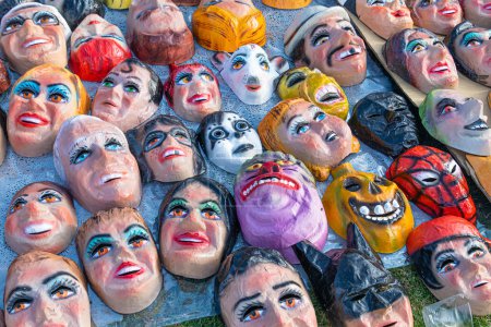 Foto de Cuenca, Ecuador - 29 de diciembre de 2022: Máscaras divertidas, cómicas y políticas para Monigotes o muñecas de trapo en un mercado callejero. Los monigotes serán quemados a medianoche para celebrar el Año Nuevo. Tradición de Ecuador - Imagen libre de derechos