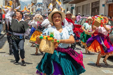 Foto de Cuenca, Ecuador - 18 de febrero de 2023: Desfile de Carnaval en Cuenca. Grupo de bailarines folclóricos de la provincia de Azuay en el centro histórico de Cuenca. La espuma se rocía sobre todo el mundo. - Imagen libre de derechos