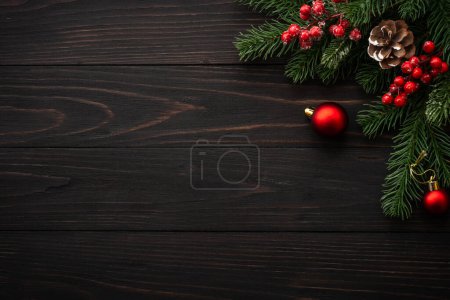 Photo for Christmas greeting card. Fir tree brunch and red decorations on wooden background. flat lay with copy space. - Royalty Free Image