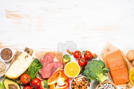 Photo for Healthy food products at white. Balanced nutrition. Salmon fish, beef, cheese, beans, nuts and vegetables with olive oil. Top view image with copy space. - Royalty Free Image