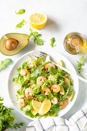 Téléchargez les photos : Shrimp salad with arugula and avocado at white. Top view with space for text. - en image libre de droit