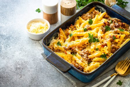 Pasta penne with minced meat, cheese and creamy sauce. Mac and cheese. Baked dish.
