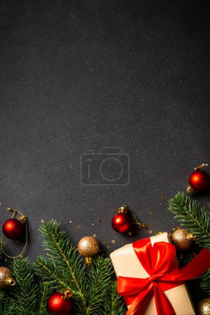 Foto de Piso de Navidad yacía fondo. Caja de regalo, abeto y decoraciones navideñas. Vista superior en negro. - Imagen libre de derechos