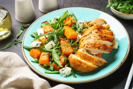 Photo for Warm salad with baked chicken breast, pumpkin, blue cheese and arugula. Dash diet, keto diet meal. - Royalty Free Image