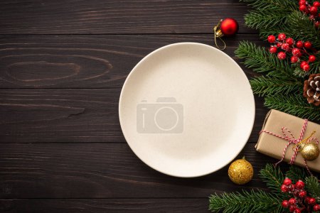 Foto de Comida navideña, cena navideña con plato artesanal y decoraciones navideñas sobre fondo de madera oscura. Vista superior con espacio de copia. - Imagen libre de derechos