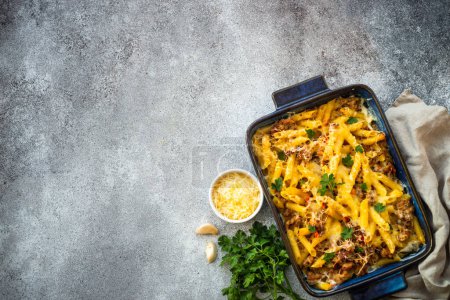 Photo for Pasta penne with minced meat, cheese and creamy sauce. Mac and cheese. Top view on stone table. - Royalty Free Image