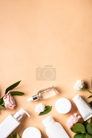 Foto de Natural cosmetic products. Cream, serum, tonic with green leaves and flowers. Skin care concept. Vertical image. - Imagen libre de derechos