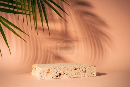 Foto de Travertine podium for presentation cosmetic products on beige background with palm leaves and shadows. art creative layout. - Imagen libre de derechos
